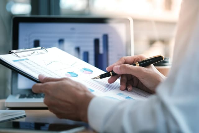 A stock image of a scientist notating a report on a clipboard