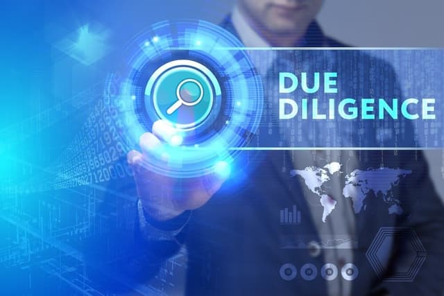 A stock image of a business man in a suit pressing a digital search button that reads Due Diligence