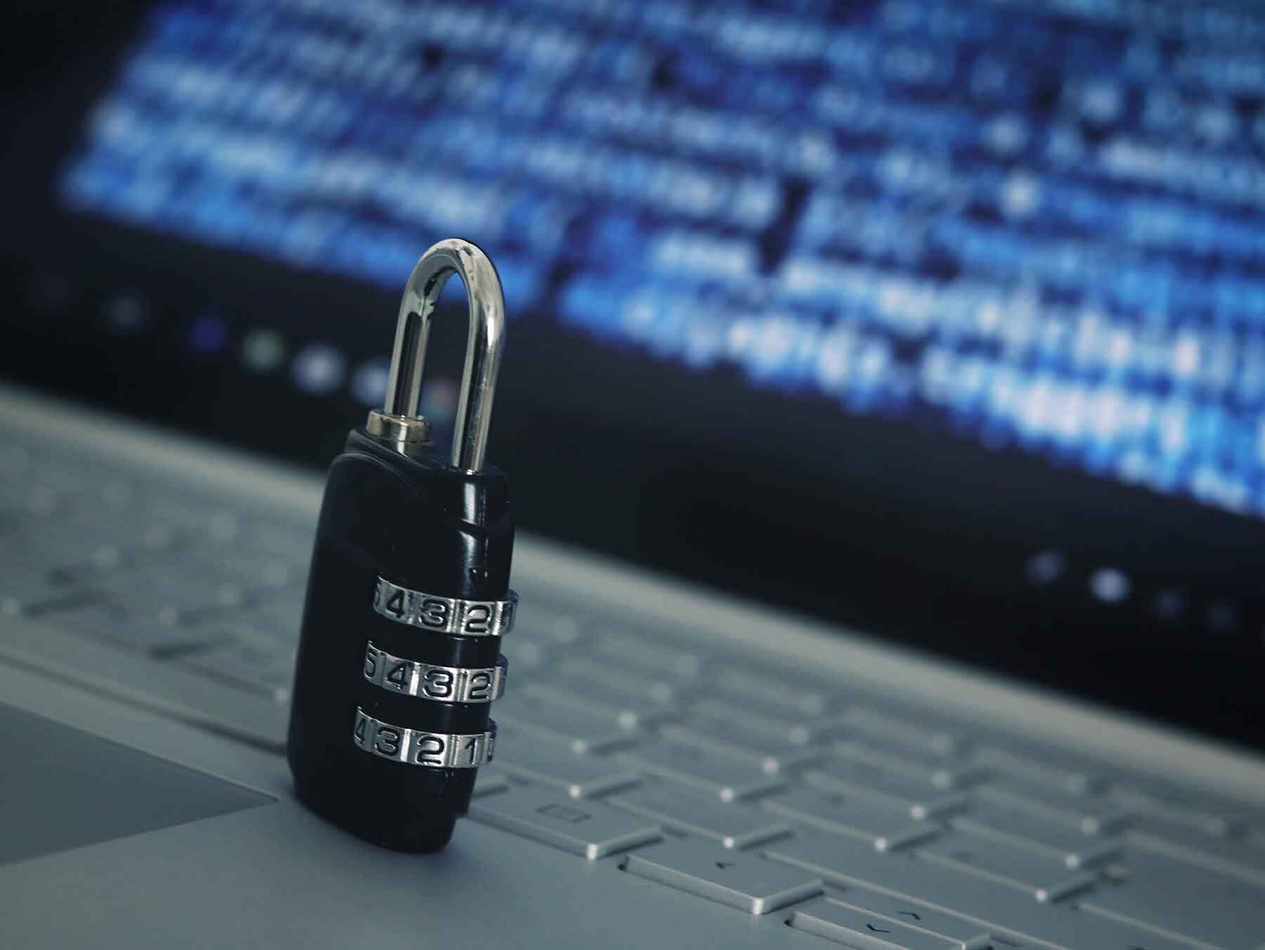 A combination lock sitting on a laptop
