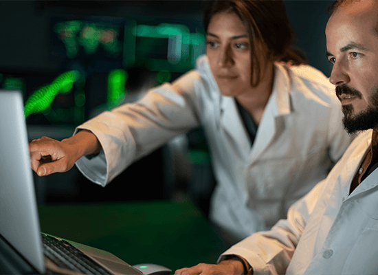Biotechnology researchers looking at results on a laptop